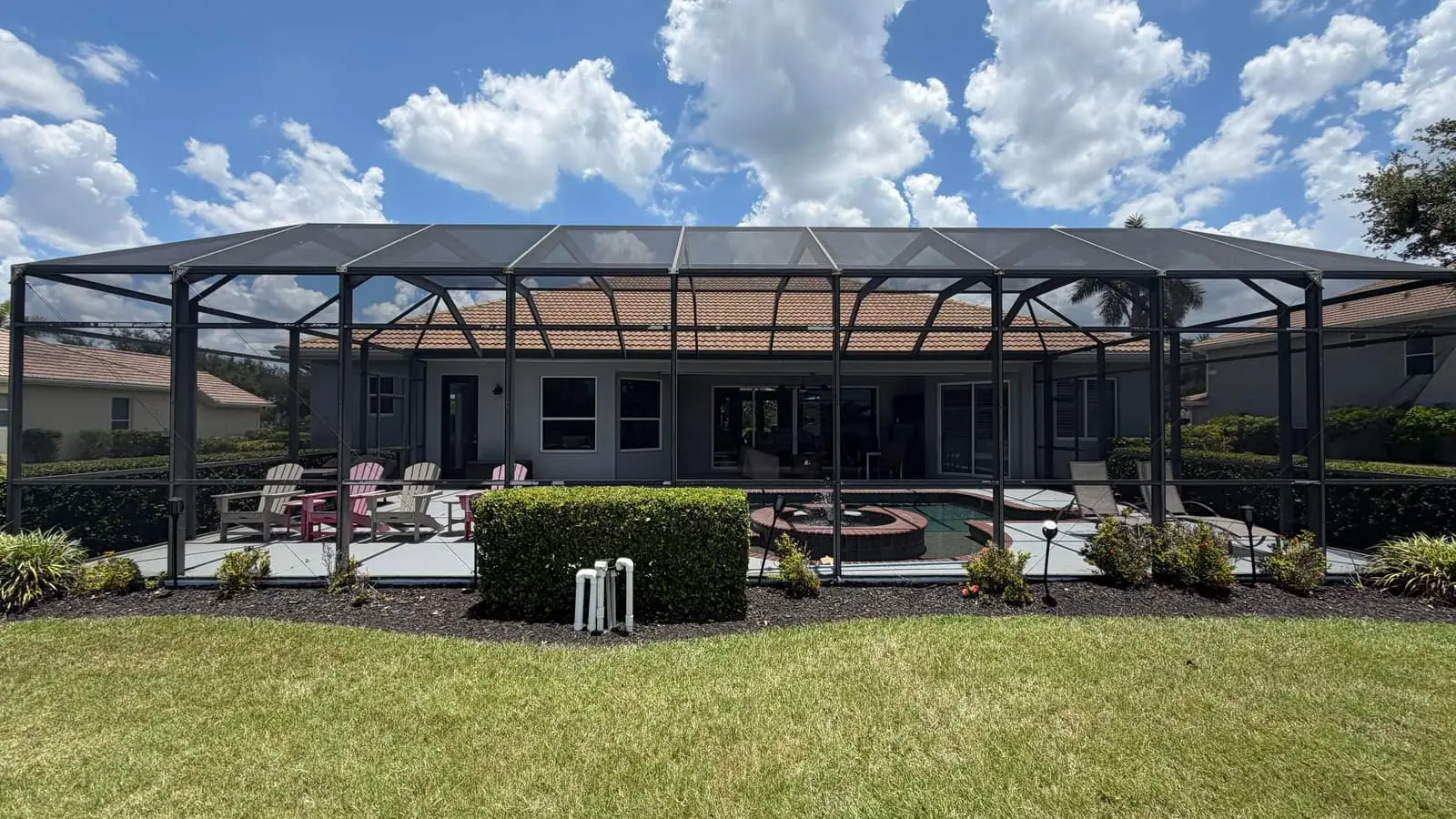 A screened pool enclosure across the back of a home