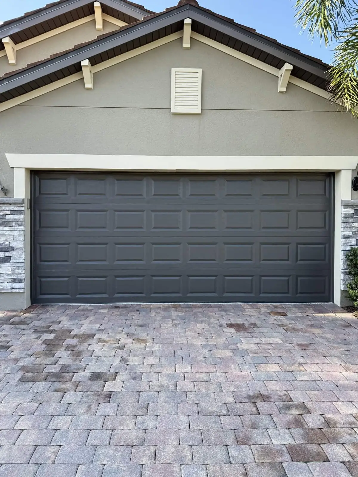 A double garage door painted dark gray