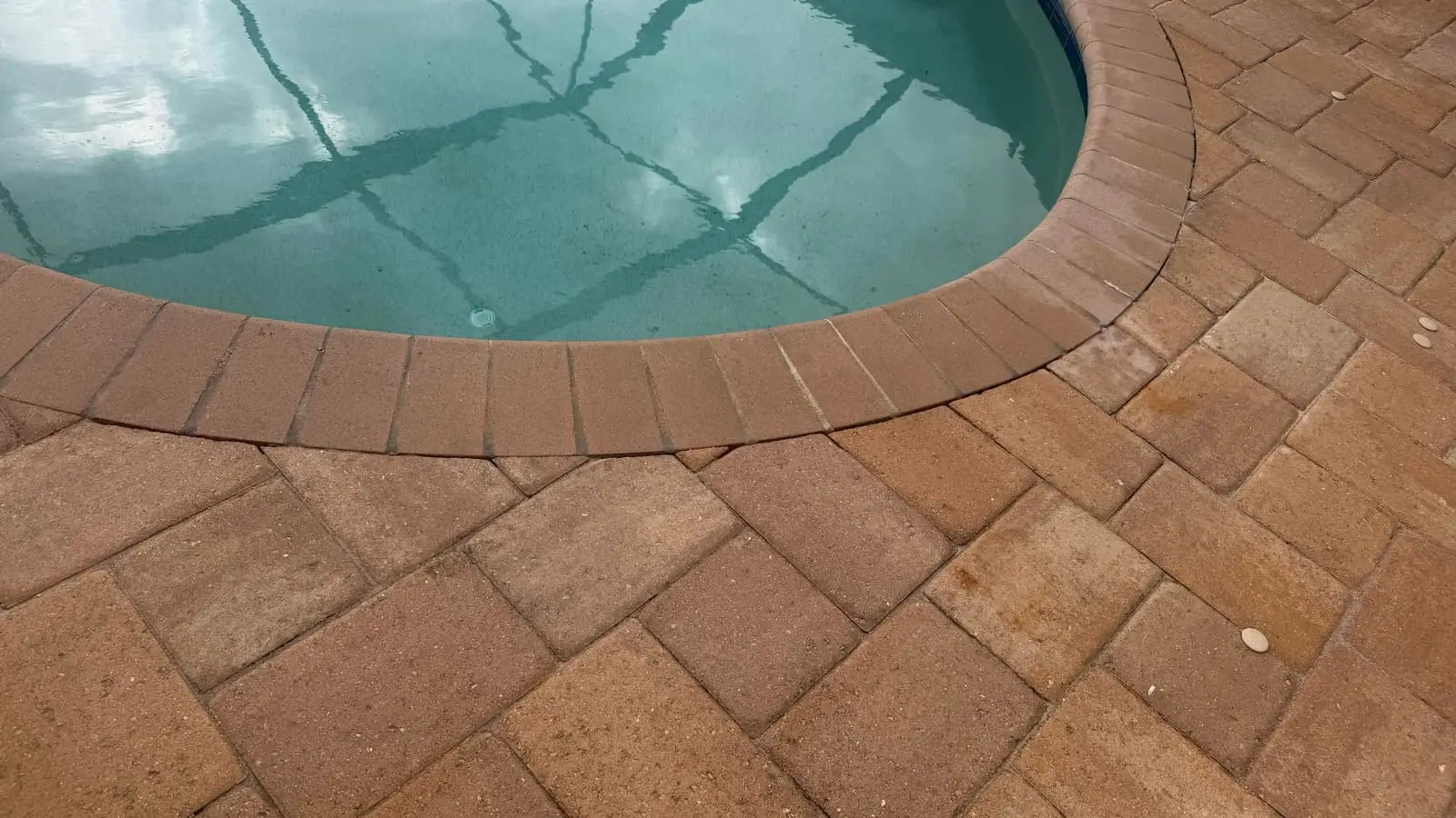 The same pool coping after sanding and sealing, with the color back in the pavers